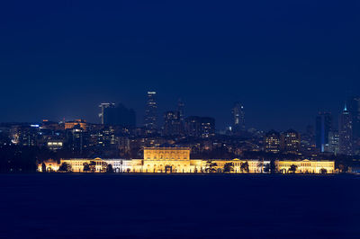 Illuminated dolmabahce palace by bosphorus at night