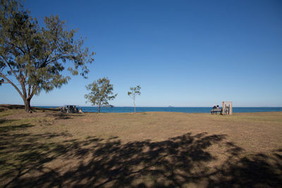 Scenic view of beach against clear blue sky