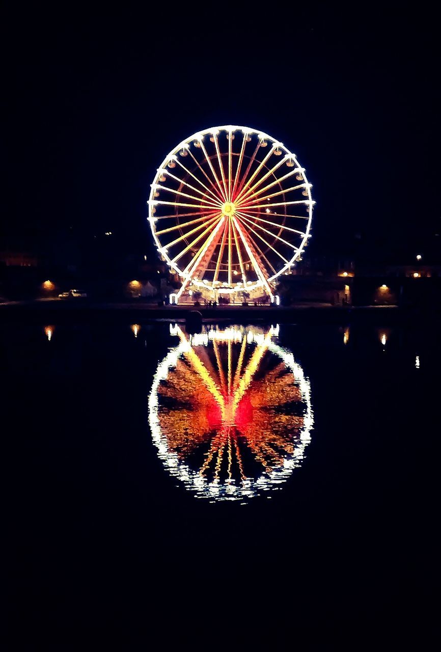 illuminated, night, ferris wheel, arts culture and entertainment, amusement park ride, sky, amusement park, reflection, glowing, low angle view, circle, built structure, water, lighting equipment, no people, outdoors, celebration, firework display, multi colored, architecture