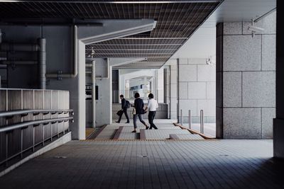 Rear view of people walking in corridor of building