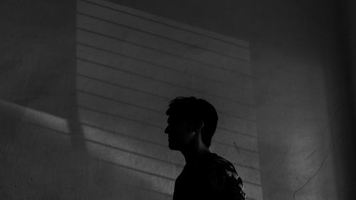 Young man standing against wall