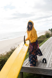 Female surfer prepares her surfboard for adventure