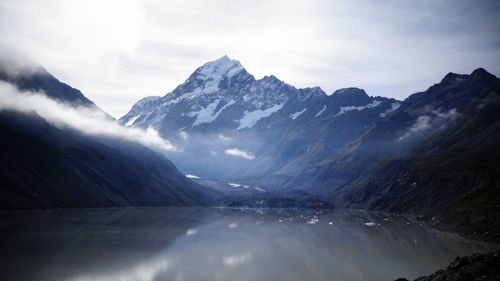 Scenic view of aoraki mt cooks by river against cloudy sky