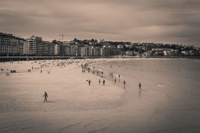 High angle view of people on beach in black and white with a slight sepia tone and grain