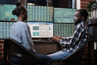 Business colleagues analyzing graph on computer