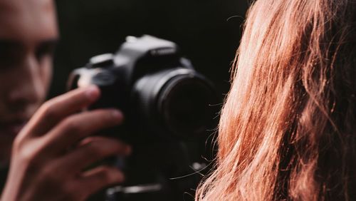 Close-up of man photographing woman