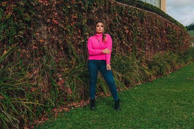 Full length portrait of woman standing by plants