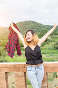 Young woman smiling while standing in park