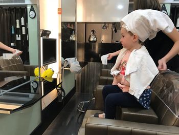 Girl with hairdresser sitting in shop