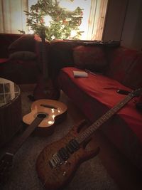 Illuminated guitar on sofa at home