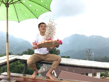 Man cleaning grains while sitting on bench