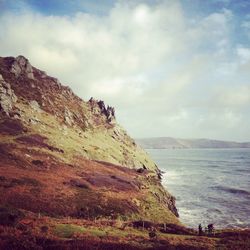 Scenic view of mountains and sea against cloudy sky