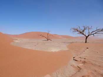 Scenic view of desert against clear blue sky