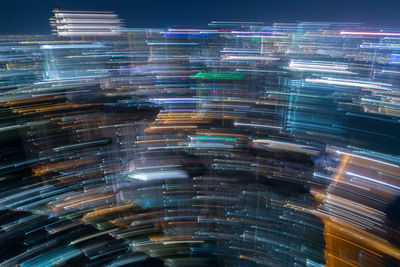 Digital composite image of illuminated modern buildings in city at night