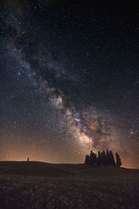 Scenic view of landscape against star field at night