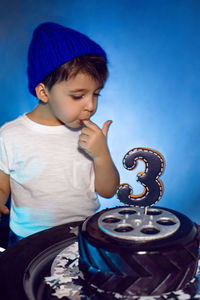 Baby boy eats his birthday cake in the form of a wheel in the studio