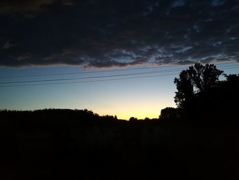 Low angle view of silhouette trees against sky