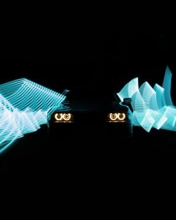 Digital composite image of hand on illuminated light over black background