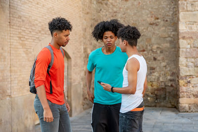 Fiends using phone while standing outdoors