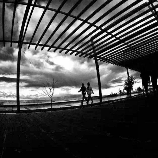 silhouette, sky, cloud - sky, lifestyles, men, leisure activity, built structure, architecture, full length, walking, standing, person, cloudy, cloud, railing, beach, sunset