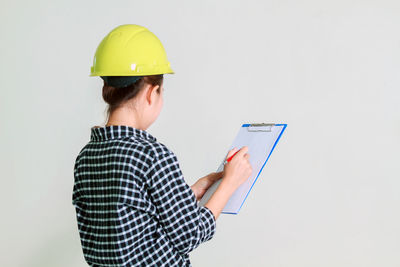 Young engineer working against white background