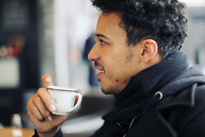 Close-up of man drinking coffee at cafe