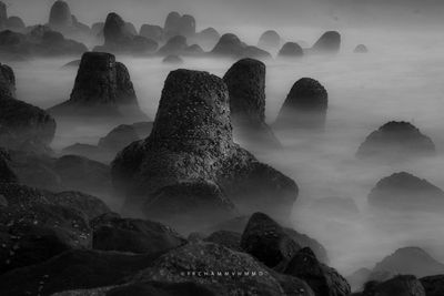 Rocks in sea against sky