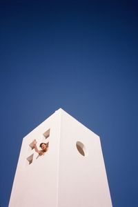 Low angle view of white building against clear blue sky