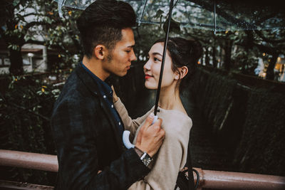 Young couple holding hands on tree