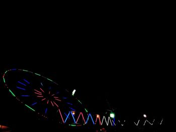 Low angle view of illuminated ferris wheel against sky at night