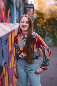 Portrait of smiling young woman standing outdoors