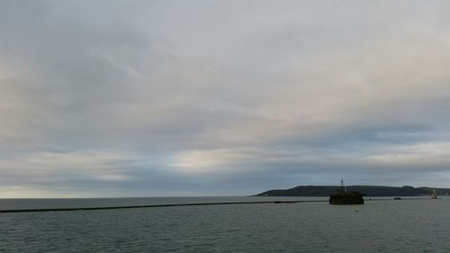 Scenic view of sea against cloudy sky