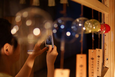 Woman photographing decoration by window