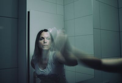 Blurred motion of woman cleaning mirror