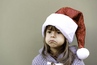 Portrait of a girl looking away against wall