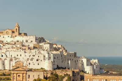 Buildings in city against clear sky