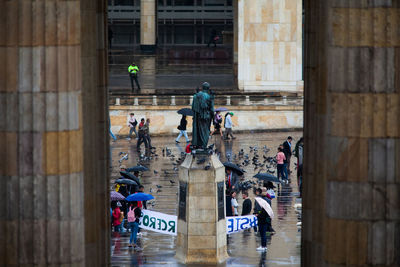 High angle view of protesters on city street during rainy season