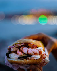 Close-up of shell and fish burger on sea shore