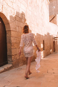 Rear view of woman walking on building