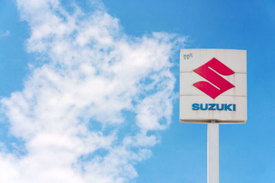 Low angle view of road sign against blue sky