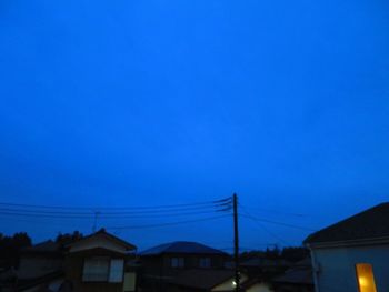 Houses against clear blue sky at night