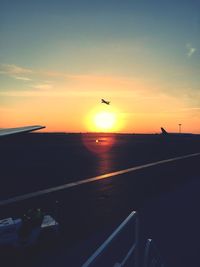 Airplane flying in sky during sunset