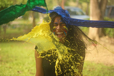 Colorful water being thrown on screaming woman at park