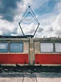 Abandoned tram against cloudy sky
