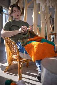 Portrait of young woman sitting on sofa at home