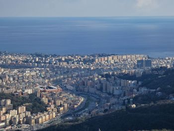 High angle view of townscape by sea against sky