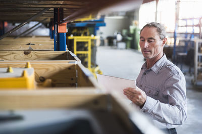 Man looking at tablet in industrial hall