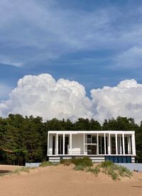 House and trees against cloud sky