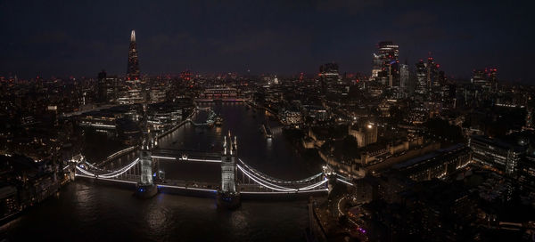 Aerial view to the illuminated tower bridge and skyline of london, uk