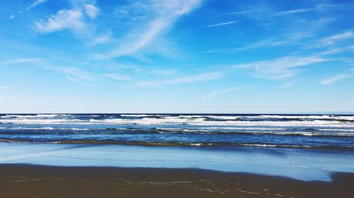 View of calm beach against blue sky